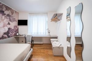 um pequeno quarto com uma cama e uma secretária em Villa Bonafata b&b em Trieste