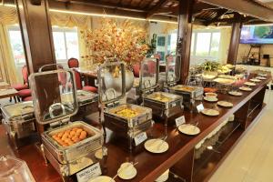 un buffet avec des assiettes de nourriture sur une table dans l'établissement Pleiku & Em Hotel by Gia Lai Tourist, à Pleiku