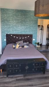 1 dormitorio con 1 cama con pared azul en Appartamento di Charme vicino al mare, en Torvaianica