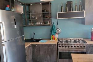 cocina con nevera de acero inoxidable y fogones en Appartamento di Charme vicino al mare, en Torvaianica