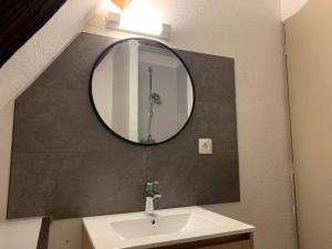 a bathroom with a sink and a mirror at Le nid d’aigles in Dole