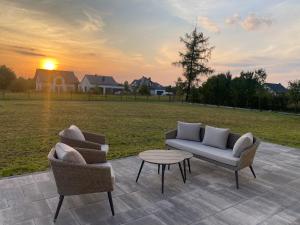dwa krzesła i stół na patio z polem w obiekcie Apartamenty na Wzgórzu Boho w mieście Zagnańsk