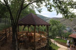 un cenador de madera con una mesa bajo un árbol en Guesthouse Pogradec, en Pogradec