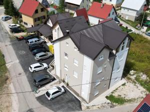 una vista aérea de una casa con coches estacionados en un estacionamiento en Premium Apartments en Žabljak