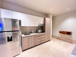a kitchen with white cabinets and a stainless steel refrigerator at Condo Gallo in Cozumel