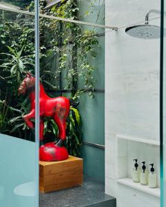 a red statue in a room with plants at Casa Mannach in Mexico City