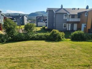 a group of houses in a yard with bushes at bjørnemyra 29h, leilighet in Alta