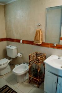 La salle de bains est pourvue de toilettes, d'un lavabo et d'un miroir. dans l'établissement Huaco Casa de Campo, à Belén