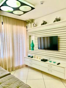 a living room with a television on a wall at Landscape Beira Mar Deluxe Vista Mar in Fortaleza