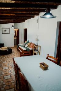 a living room with a table and a bed in a room at Huaco Casa de Campo in Belén