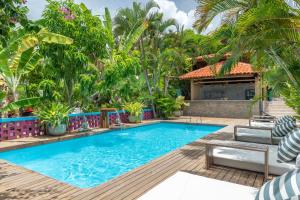 - une piscine en face d'une maison avec des palmiers dans l'établissement Vila Anauá, à Japaratinga