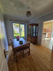 a dining room with a wooden table and chairs at 3 bedroom Semi detached in Erith