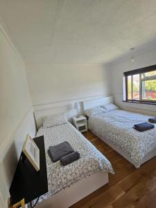 um quarto com 2 camas e uma janela em 3 bedroom Semi detached em Erith