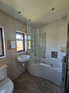 ein Badezimmer mit einer Badewanne, einem Waschbecken und einem WC in der Unterkunft 3 bedroom Semi detached in Erith
