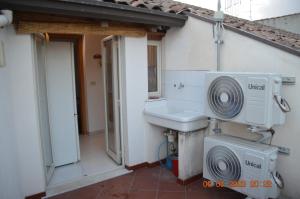 un baño con lavabo y un ventilador junto a una casa en Gli appartamenti del Casino dei Civili, en Trecastagni
