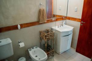 a bathroom with a sink and a toilet and a mirror at Huaco Casa de Campo in Belén