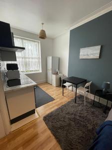 a living room with a table and a kitchen at Wonderful fully-equipped studio near Central London in London