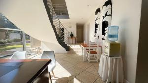 a room with a staircase and a kitchen with chairs at Sizanazo Guest House - in the Heart of Northcliff Hill in Johannesburg