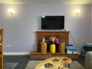 a living room with a tv on a brick fireplace at Cottage in Bretforton, north of the Cotswolds in Bretforton