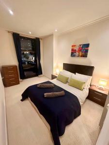 Un dormitorio con una cama grande y una ventana en NEW Two Bedroom Apartment with Balcony, en Londres