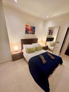 1 dormitorio con 1 cama grande con manta azul en NEW Two Bedroom Apartment with Balcony, en Londres