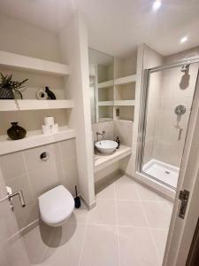 a bathroom with a shower and a toilet and a sink at NEW Two Bedroom Apartment with Balcony in London