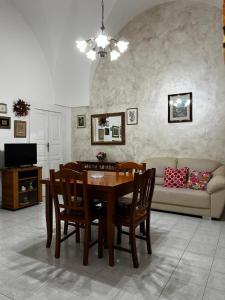 a living room with a table and chairs and a couch at Casa Verde in Mesagne