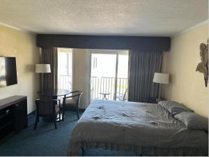 um quarto de hotel com uma cama, uma mesa e cadeiras em Condo less than 5 min from Airport with Sunset Views em Tampa