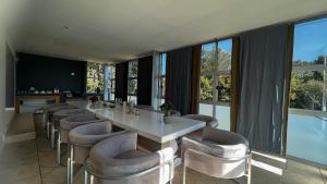 uma sala de jantar com uma mesa longa e cadeiras em Sizanazo Guest House - in the Heart of Northcliff Hill em Joanesburgo