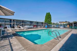 a large swimming pool with chairs and a building at Motel 6-Bend, OR in Bend