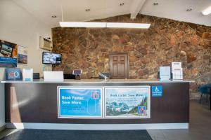 a lobby with a stone wall and a cashier counter at Motel 6-Bend, OR in Bend