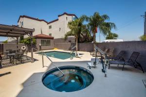 una piscina con bañera de hidromasaje en un patio en Best Western Gold Poppy Inn, en Tucson