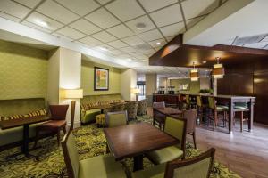um átrio do hotel com mesas e cadeiras e um bar em Hampton Inn Meridian em Meridian
