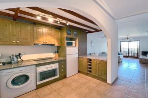 a kitchen with a washer and dryer in a room at Roda, Sea and Golf in Roda