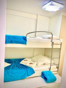 a room with two bunk beds with blue sheets at Landscape Beira Mar Deluxe Vista Mar in Fortaleza