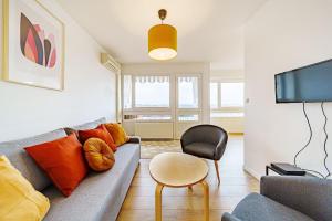 uma sala de estar com um sofá e uma cadeira em Charmant 2 chambres rénové avec balcon-Oullins em Oullins