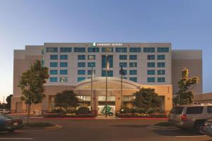 a building with a car parked in a parking lot at Embassy Suites by Hilton Portland Airport in Portland