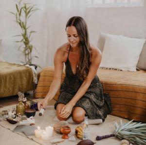 a woman in a dress sitting on the floor with candles at Unicorn Reborn - Peaceful Rentals in San Marcos La Laguna