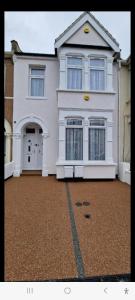 Casa blanca con puerta y entrada en Stylish 2Bedroom flat near train station in London, en Seven Kings