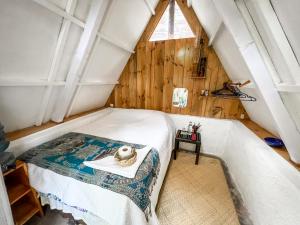 a bedroom with a bed in a attic at Unicorn Reborn - Peaceful Rentals in San Marcos La Laguna