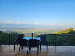 a table and chairs on a balcony with a view at Guest House Kusika in Sighnaghi