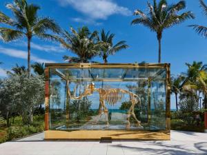 a glass display case with a dinosaur statue in it at Faena Hotel Miami Beach in Miami Beach