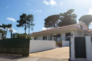 a house with a white fence and a gate at Casa Casal da Eva in Alcobaça