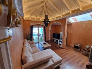 a living room with a couch and a tv at Villa Habibi Luxury 5A in Chayofa