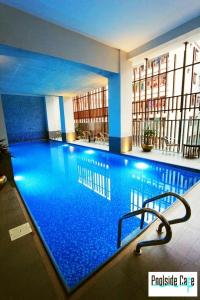 a large swimming pool with blue water in a building at Sky City Hotel Dhaka in Dhaka