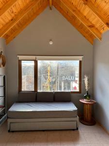 uma cama num quarto com uma janela em Los Alerces Patagonia Apart em Esquel