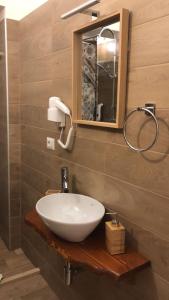 W łazience znajduje się biała umywalka i lustro. w obiekcie Castrum Rooms w mieście Mesagne