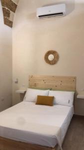sypialnia z białym łóżkiem i wentylatorem w obiekcie Castrum Rooms w mieście Mesagne