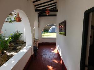 un pasillo de una casa con una entrada arqueada en Casa Hotel Paraíso Bella Villa en Villa de Leyva
