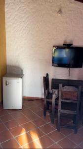 Habitación con mesa y TV en la pared. en CABAÑAS VILLA EMILY, en Curití